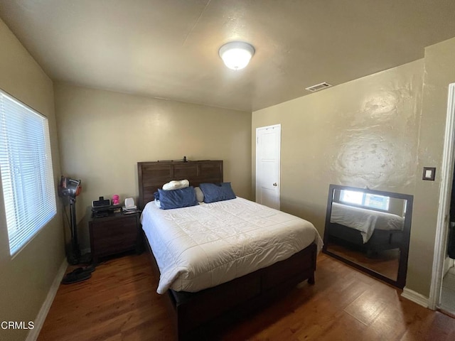 bedroom with dark hardwood / wood-style floors