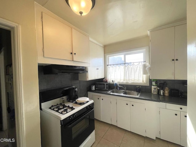 kitchen featuring decorative backsplash, sink, light tile patterned flooring, white cabinetry, and gas range oven