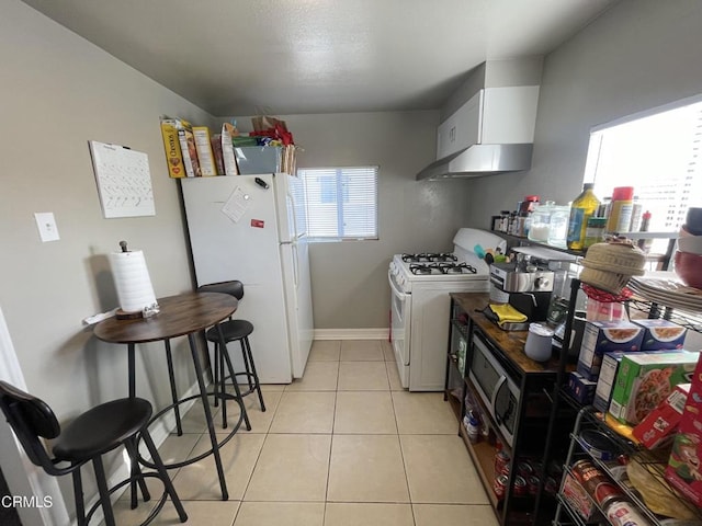 kitchen featuring light tile patterned floors, white appliances, and white cabinets