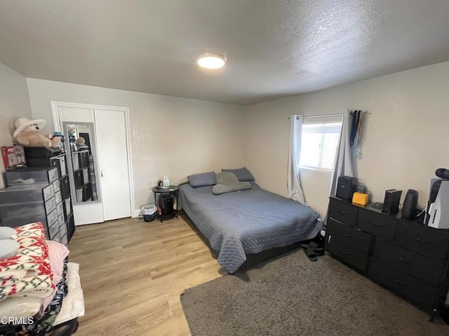 bedroom featuring a textured ceiling and light hardwood / wood-style floors