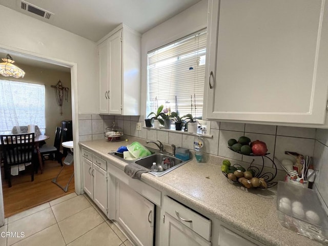 kitchen with sink, white cabinetry, light tile patterned floors, and tasteful backsplash