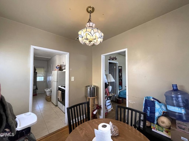 dining space featuring light tile patterned floors and a chandelier