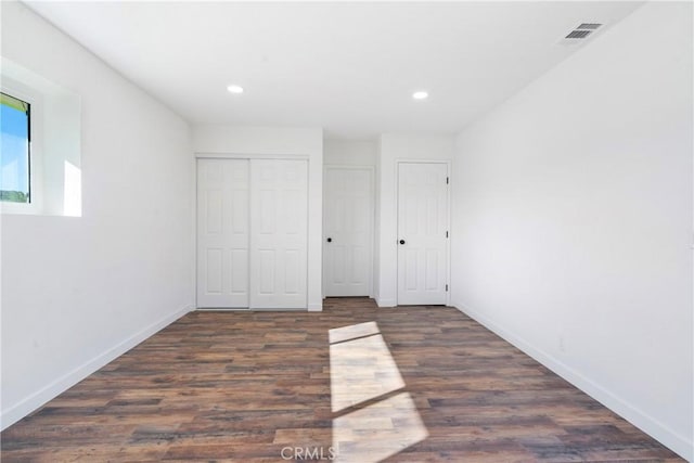 unfurnished bedroom featuring recessed lighting, visible vents, baseboards, and wood finished floors