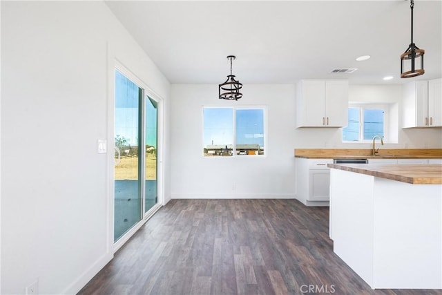 kitchen with visible vents, a sink, dark wood-style floors, white cabinetry, and wooden counters