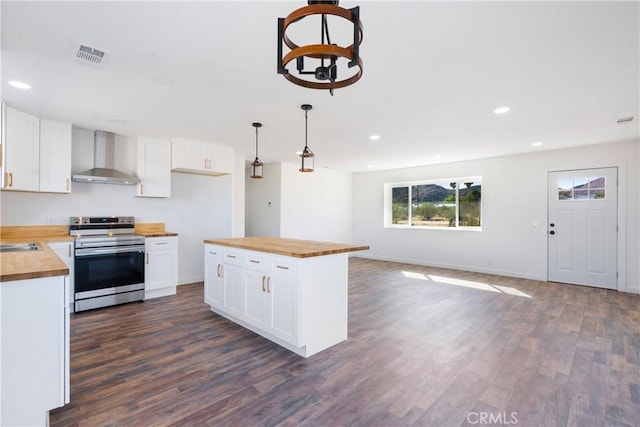 kitchen featuring visible vents, wood counters, stainless steel electric range, dark wood-style floors, and wall chimney exhaust hood