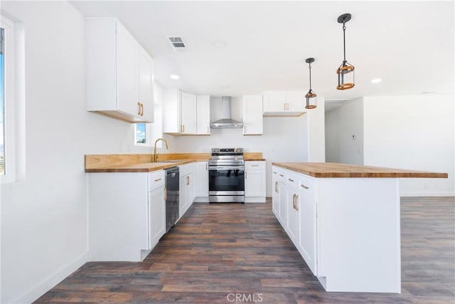 kitchen featuring stainless steel electric range oven, visible vents, dishwasher, wall chimney exhaust hood, and butcher block counters