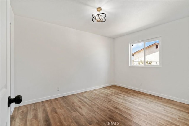 empty room featuring wood finished floors and baseboards