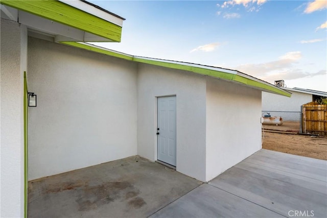 exterior space featuring a patio, fence, and stucco siding