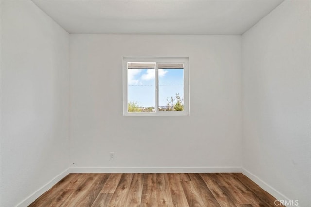 unfurnished room featuring wood finished floors and baseboards