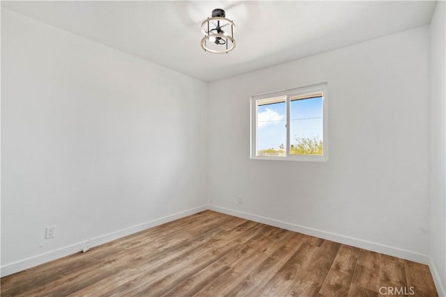 unfurnished room featuring baseboards and wood finished floors