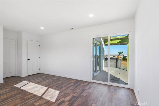 spare room with recessed lighting, baseboards, and dark wood-type flooring