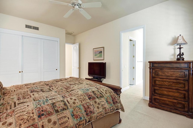 bedroom with ceiling fan, a closet, and light colored carpet