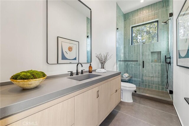 bathroom featuring toilet, a shower with door, tile patterned floors, and vanity