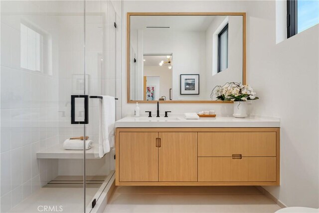 bathroom featuring walk in shower, vanity, tile patterned flooring, and a healthy amount of sunlight