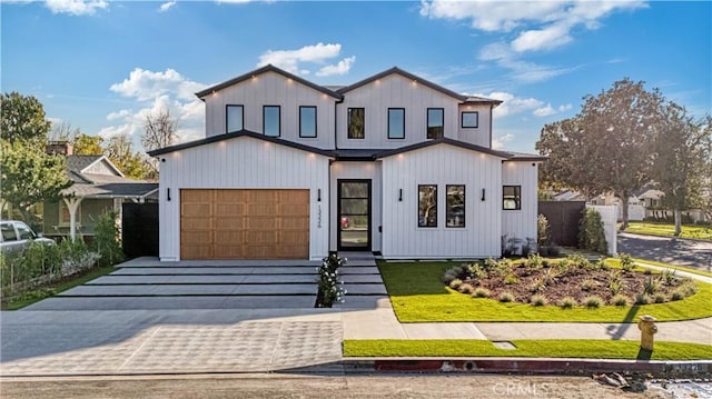 modern farmhouse with a garage and decorative driveway