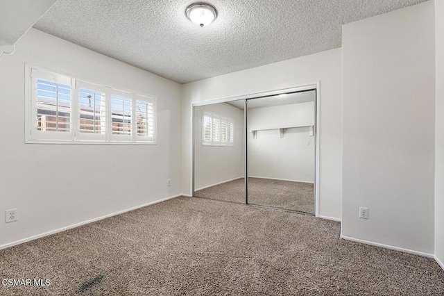 unfurnished bedroom featuring a closet, a textured ceiling, and carpet floors