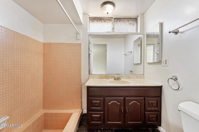 bathroom featuring walk in shower, vanity, and toilet