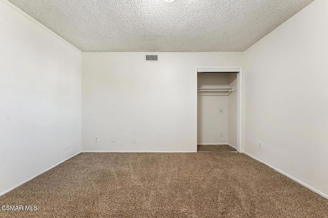 unfurnished bedroom featuring a textured ceiling, a closet, and carpet