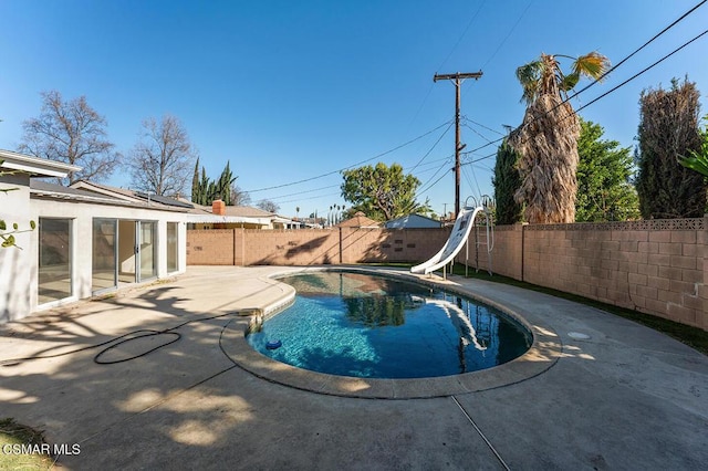 view of swimming pool featuring a patio and a water slide