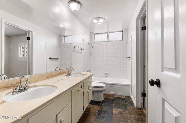 full bathroom featuring tiled shower / bath, vanity, plenty of natural light, and toilet