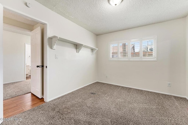 spare room featuring carpet floors and a textured ceiling