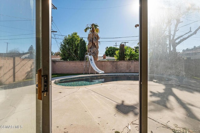 view of swimming pool with a water slide and a patio