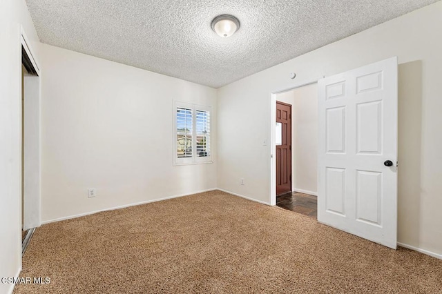 unfurnished bedroom featuring carpet floors and a textured ceiling