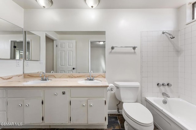 full bathroom featuring vanity, tiled shower / bath combo, and toilet