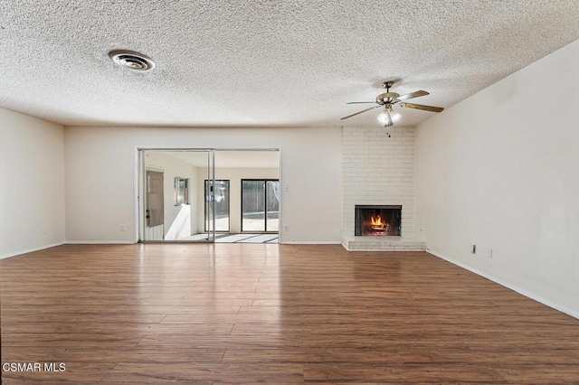 unfurnished living room featuring ceiling fan, hardwood / wood-style floors, a textured ceiling, and a fireplace