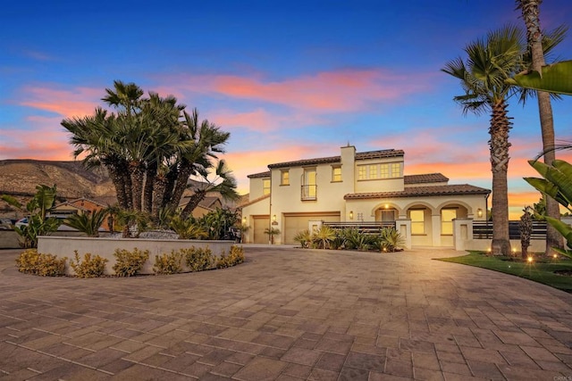 mediterranean / spanish-style home featuring solar panels and a garage