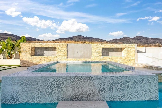 view of swimming pool with a hot tub and a mountain view