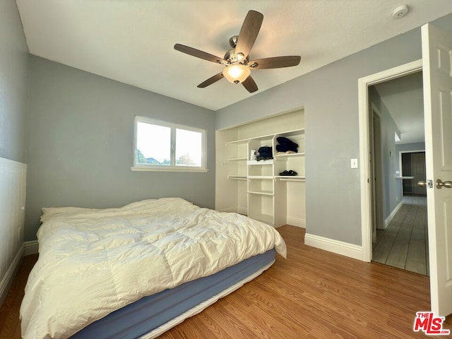 bedroom with ceiling fan, a closet, and wood-type flooring