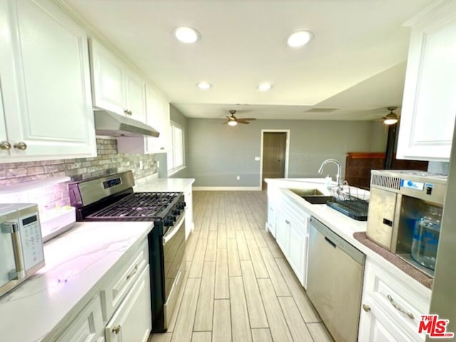 kitchen featuring appliances with stainless steel finishes, white cabinets, and sink