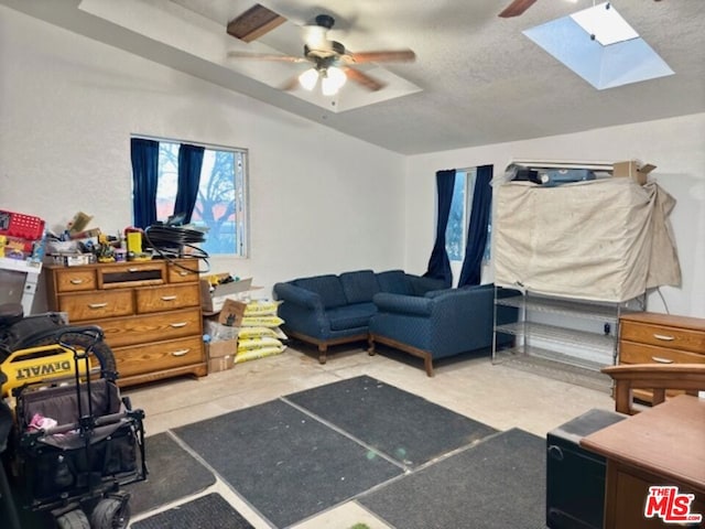 bedroom featuring ceiling fan, a skylight, and a textured ceiling