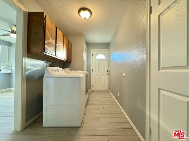 washroom with ceiling fan, washing machine and dryer, and cabinets