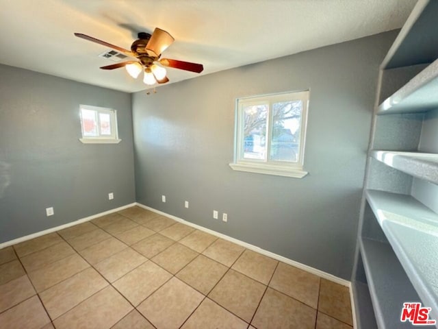 tiled spare room featuring ceiling fan