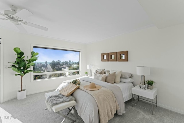 carpeted bedroom featuring crown molding and ceiling fan