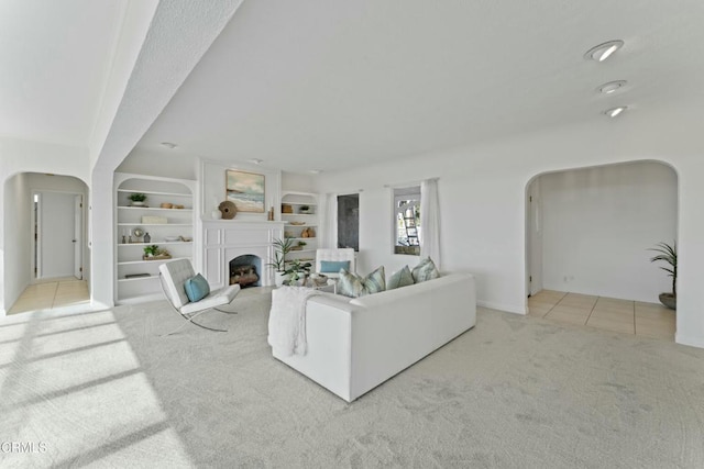 living room with built in shelves and light colored carpet