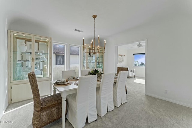 carpeted dining area featuring a notable chandelier