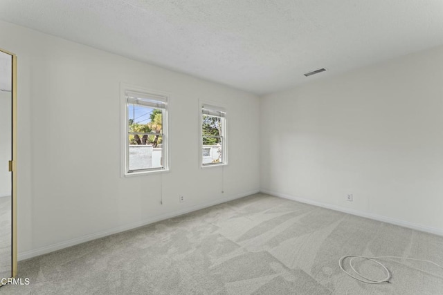 carpeted spare room with a textured ceiling