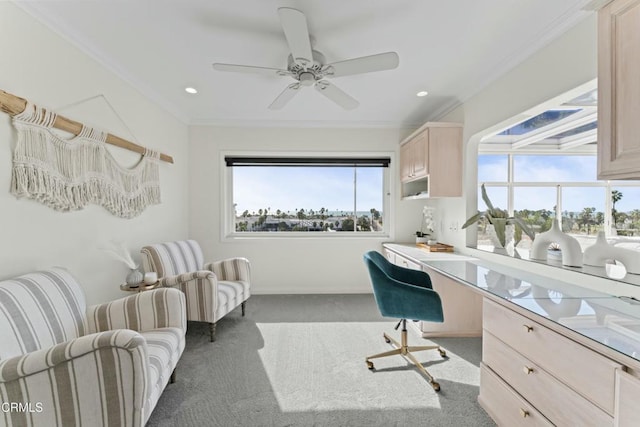 office space featuring carpet floors, built in desk, ornamental molding, and ceiling fan