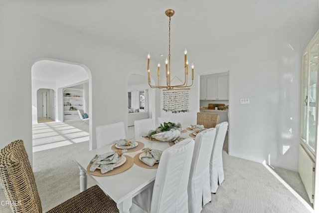 carpeted dining room with a notable chandelier and built in shelves