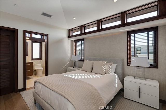 bedroom featuring ensuite bath, multiple windows, visible vents, and recessed lighting