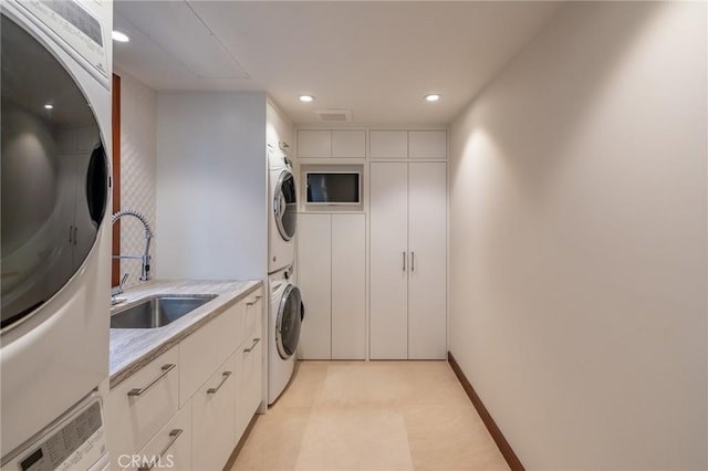 washroom with light floors, recessed lighting, visible vents, a sink, and stacked washing maching and dryer