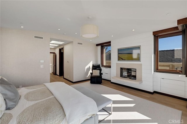 bedroom with baseboards, wood finished floors, visible vents, and recessed lighting