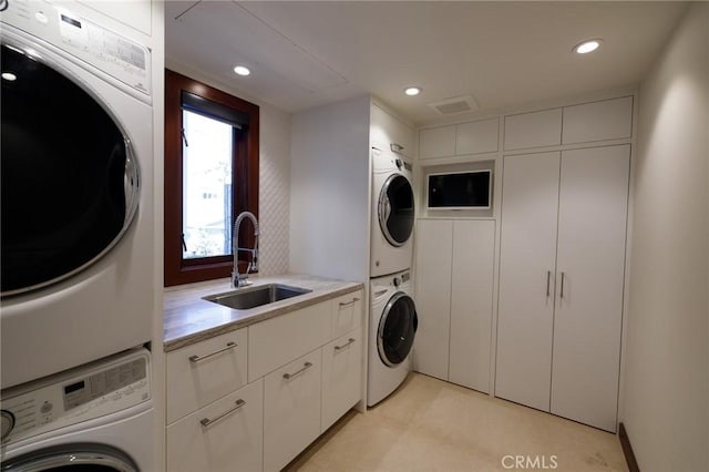 washroom featuring stacked washer and dryer, recessed lighting, and a sink