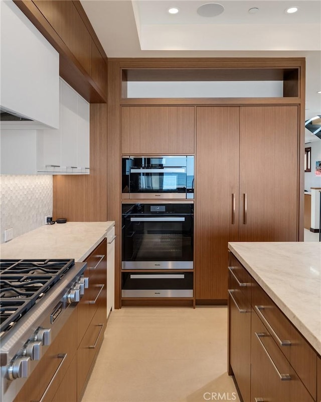 kitchen with a warming drawer, double wall oven, recessed lighting, stainless steel gas stovetop, and backsplash