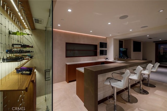 bar with visible vents, indoor wet bar, a sink, and recessed lighting