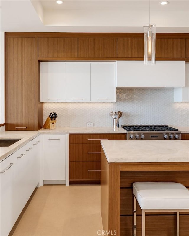 kitchen featuring light countertops, ventilation hood, white cabinets, and stainless steel gas stovetop