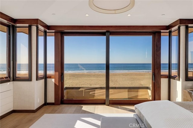 unfurnished sunroom featuring a water view and a beach view